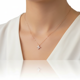 Girocollo mini fiore in oro rosa indossato su camicetta bianca senza watermark